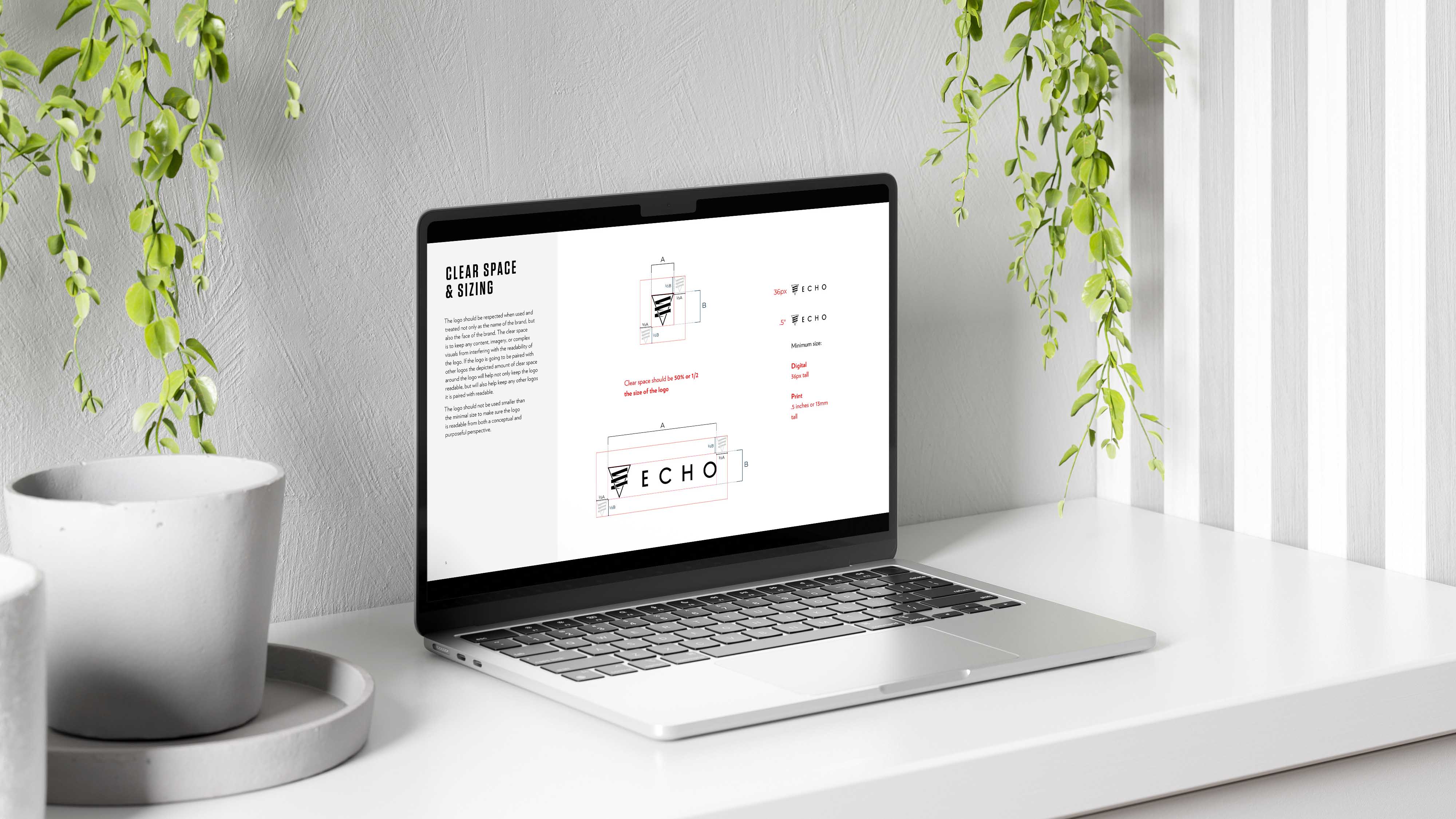 A macbook computer open and set on a white tabletop. On the screen of the computer is a white background a several versions of the Echo logo. The logos are specifically calling proportions and measurements from the logo guidelines.