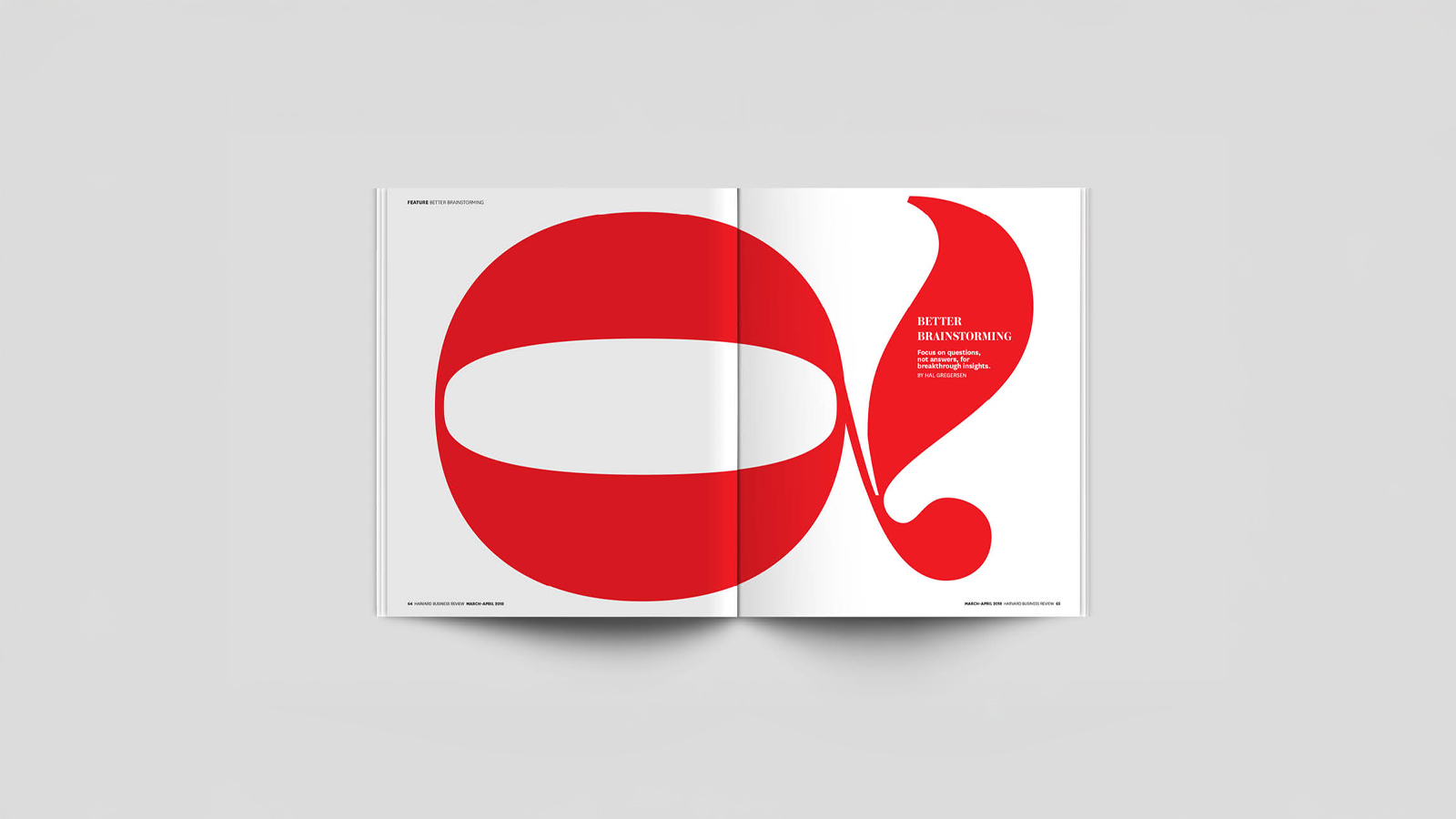 An image of a magazine opened to a spread. The spread has a large letter Q across both pages. Made in Adobe Indesign