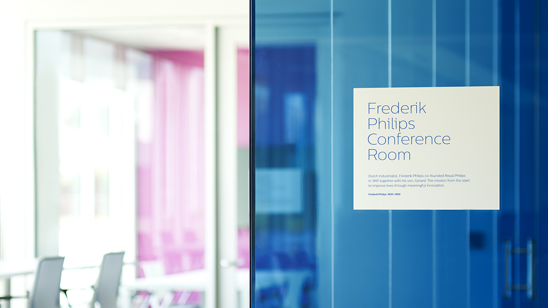 A photograph of blue glass with room signage hanging.