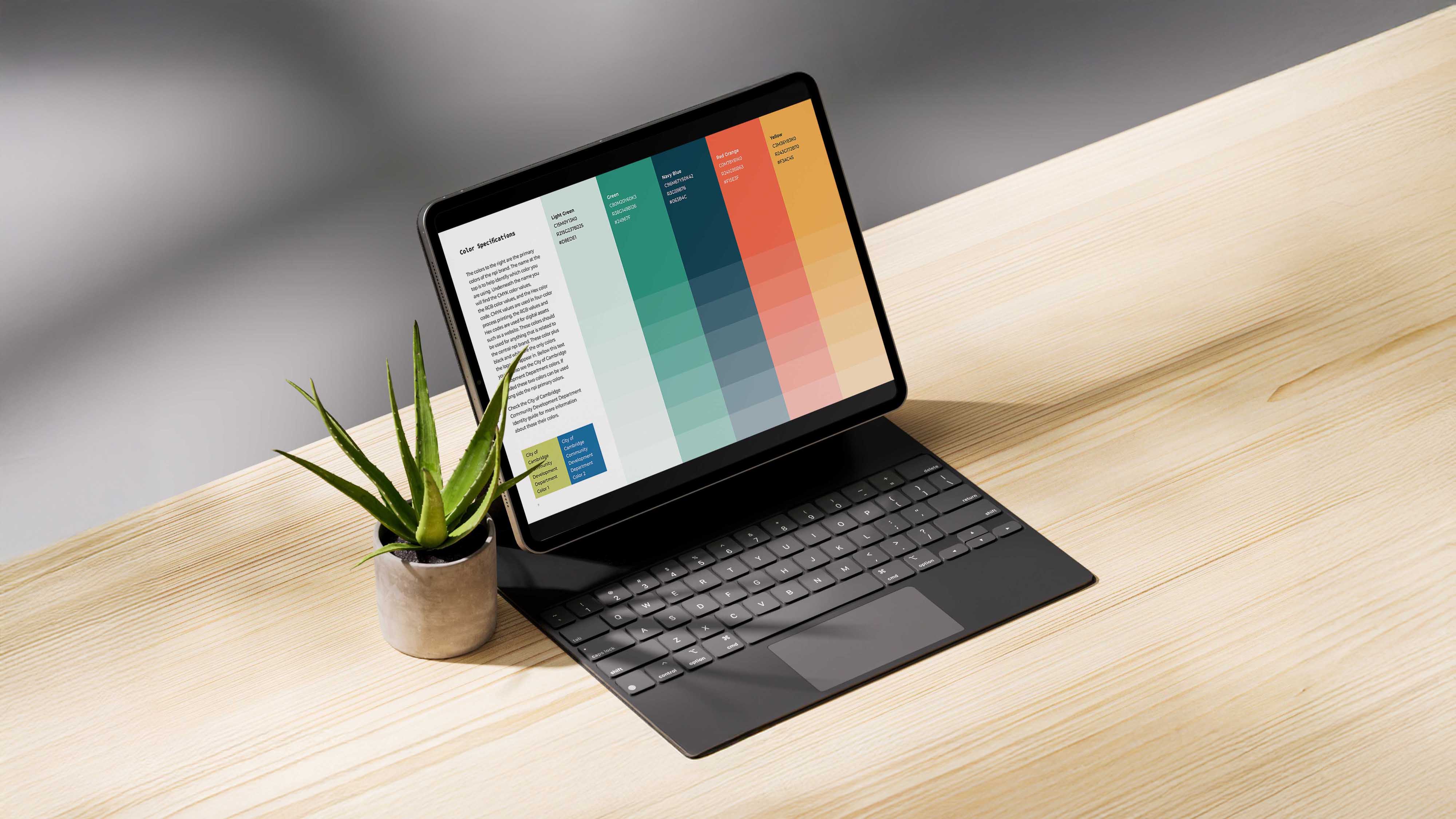 An image of an ipad on a wooden table. on the screen of the ipad has a color palette with typography. design made in Adobe Indesign and Illustrator.