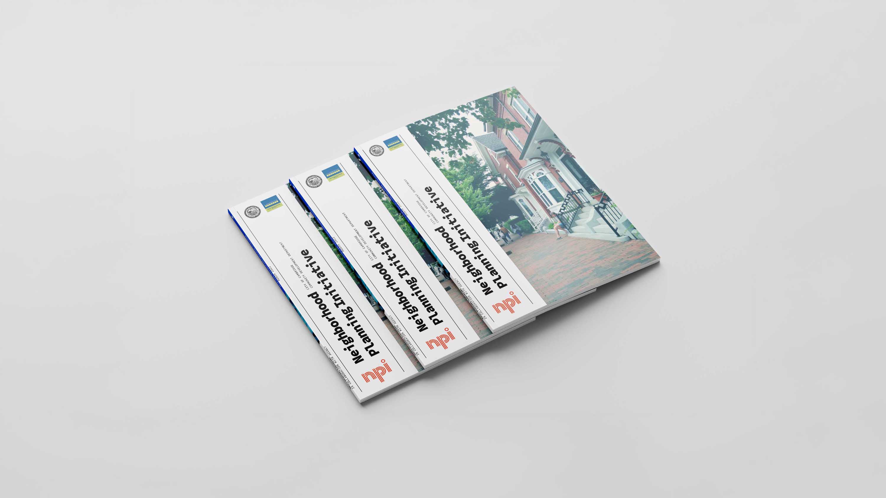 An image of three books stacked on top of eachother. All books are the same. The cover has a white rectangle on the left and images of houses on the right. design made in Adobe Indesign