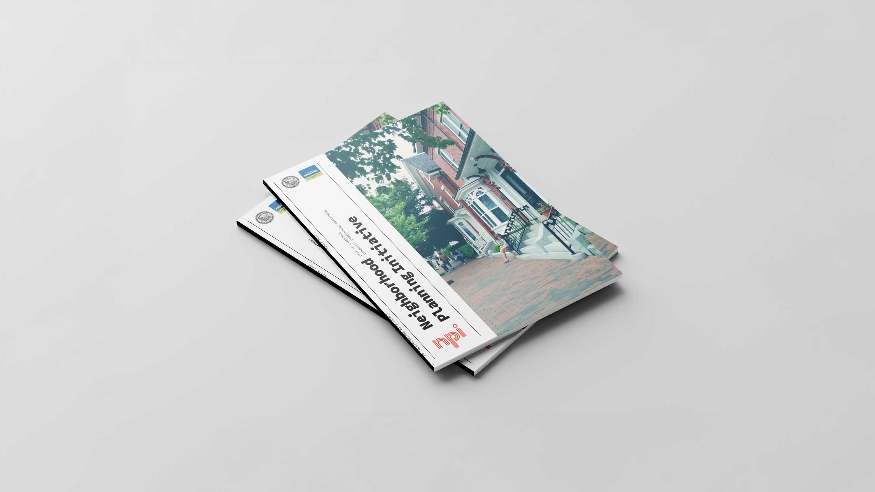 An image of two books stacked on top of eachother. All books are the same. The cover has a white rectangle on the left and images of houses on the right. design made in Adobe Indesign