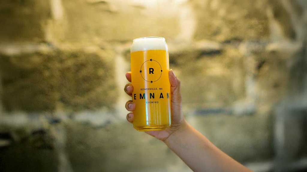 A photograph of a drinking glass the shape of a beer can. The glass is being held by a persons hand and has a circular logo eith the letter R in the middle stacked ontop of typography. Design made with Adobe Illustrator.
